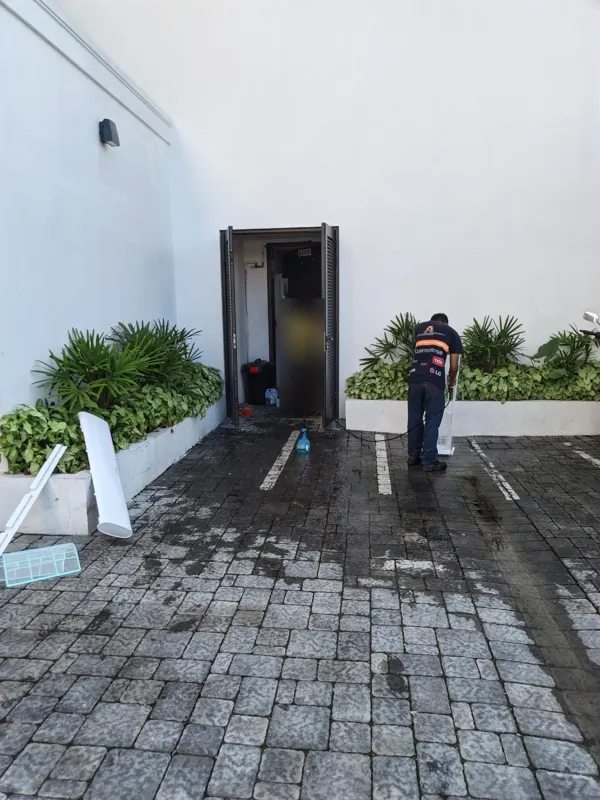 Técnico de Alvarado Solutions lavando las piezas de un aire acondicionado split afuera de un restaurante en Samborondón