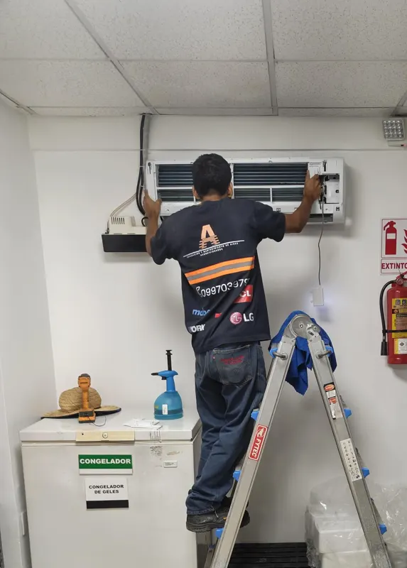 Técnico de Alvarado Solutions dando mantenimiento a un aire acondicionado split en la bodega de una oficina del Parque Empresarial Colón, Guayaquil